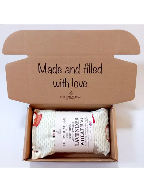 Open box with a lavender wheat bag inside. Text: "Made and filled with love".