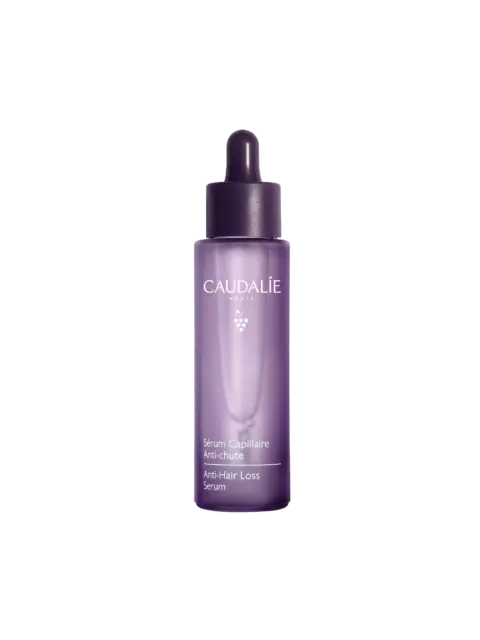Purple bottle of Caudalie Anti-Hair Loss Serum with dropper lid.