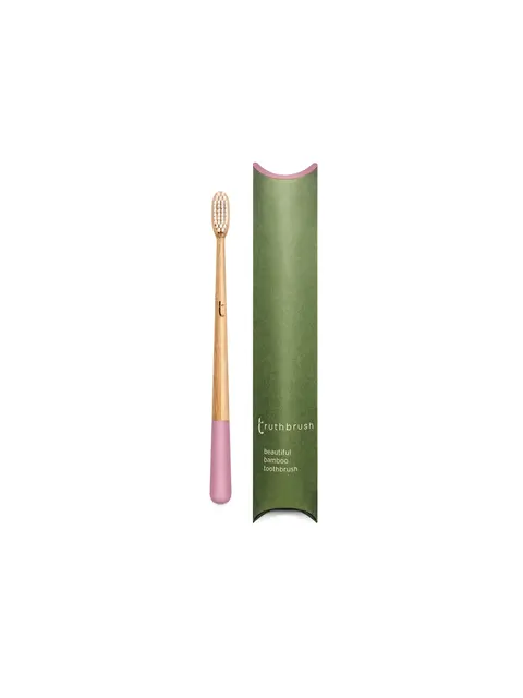 Bamboo toothbrush with pink handle, green packaging labelled "truthbrush".