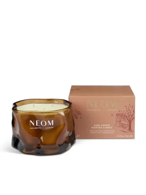 Brown glass candle jar with "NEOM Wellbeing London" text, next to a matching box.