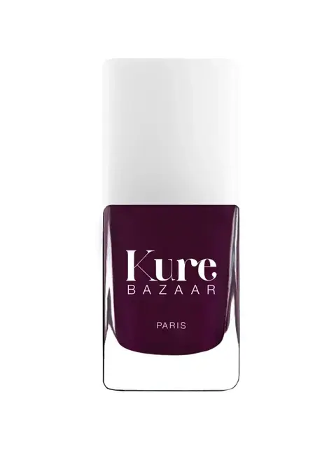 Kure Bazaar nail polish bottle, dark purple shade, white cap.