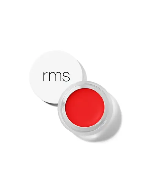 Red lip balm in a clear pot with a white lid displaying "rms".