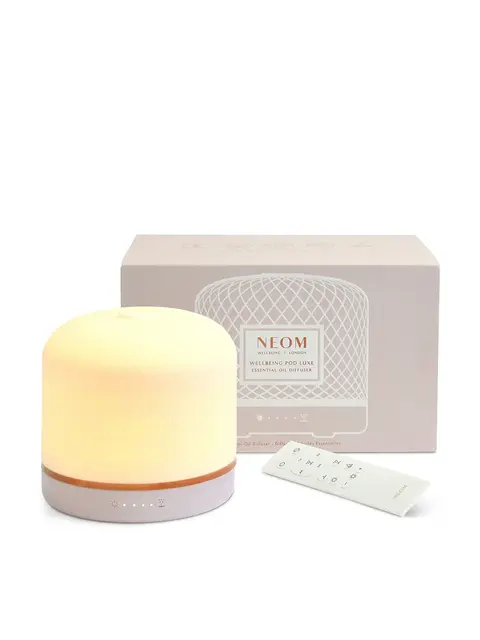Essential oil diffuser with remote and packaging. Neom branding visible.