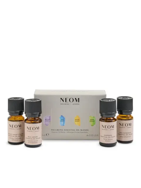 NEOM Wellbeing Essential Oil Blends set with four bottles in front of packaging.