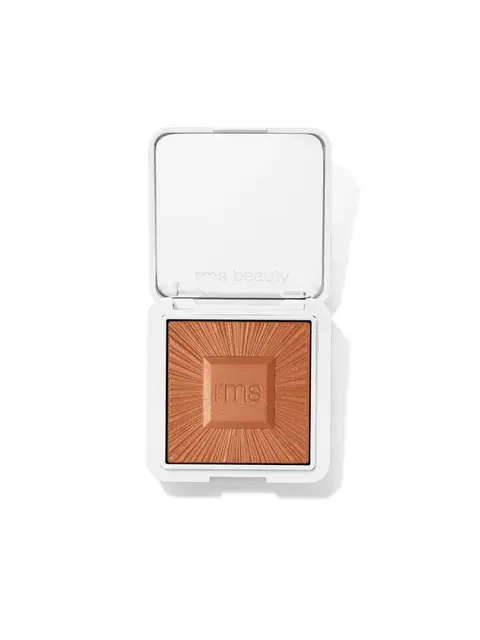 Open compact with bronze powder, "rms beauty" embossed on lid and powder.