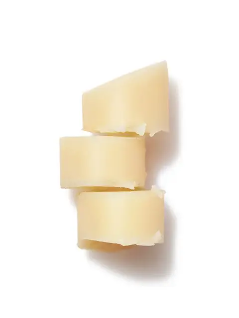 Three stacked pieces of solid beige cocoa butter on a white background.