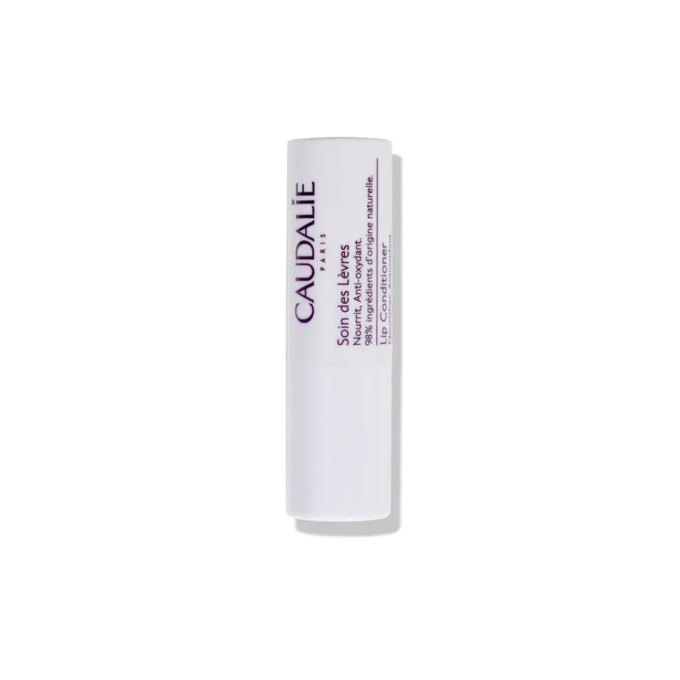 White tube of Caudalie lip conditioner with text on side.