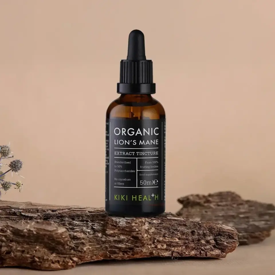 Brown dropper bottle labelled "Organic Lion's Mane Extract Tincture" on wooden surface.
