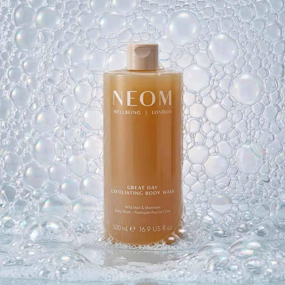 NEOM Great Day Exfoliating Body Wash, 500ml, surrounded by bubbles.