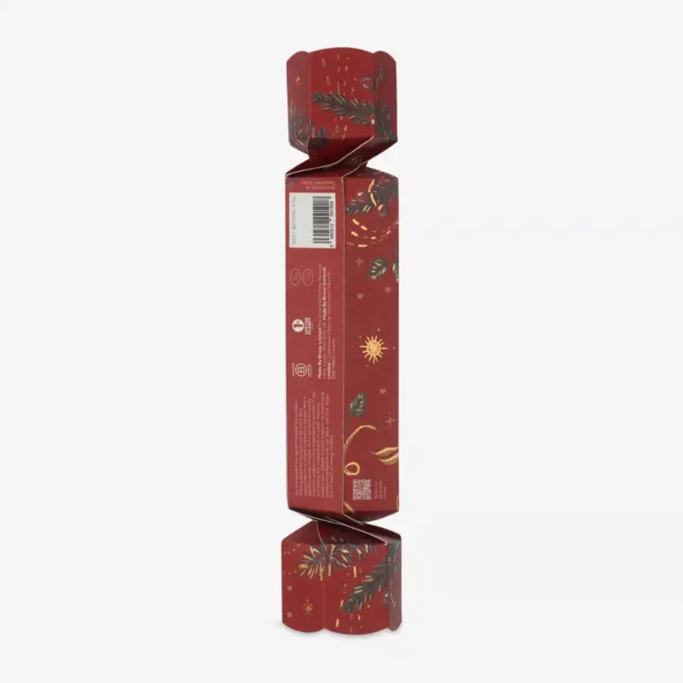 Red festive cracker with gold and green leaf design, barcode visible on side.