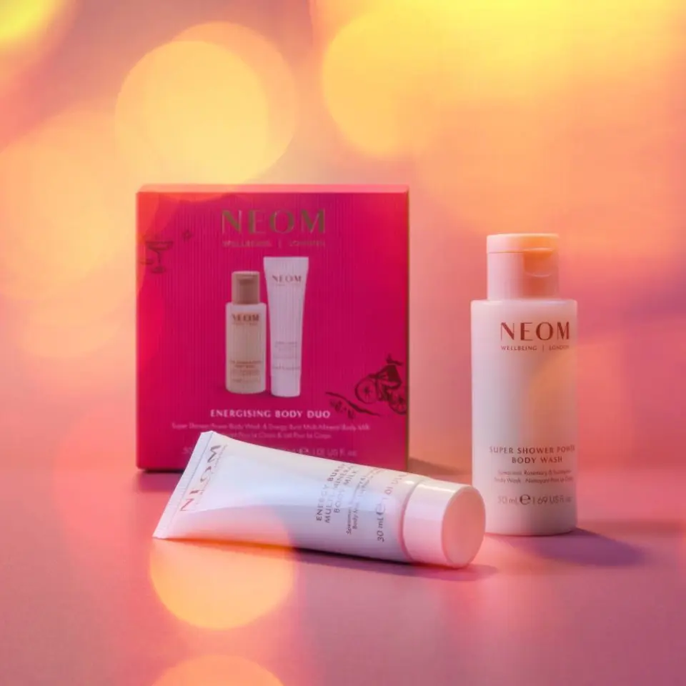 NEOM Energising Body Duo set with body wash and lotion on a pink background.