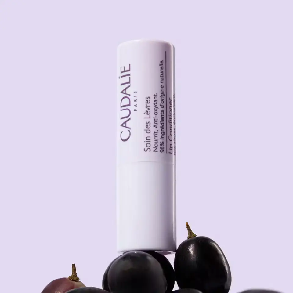 Lip conditioner tube with grapes, text in French and English.