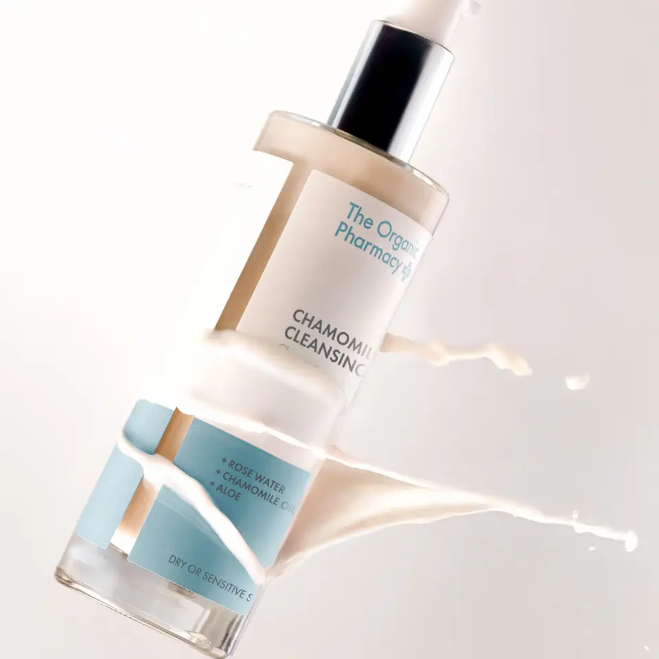 Chamomile cleansing milk bottle with liquid splash, labelled for dry or sensitive skin.