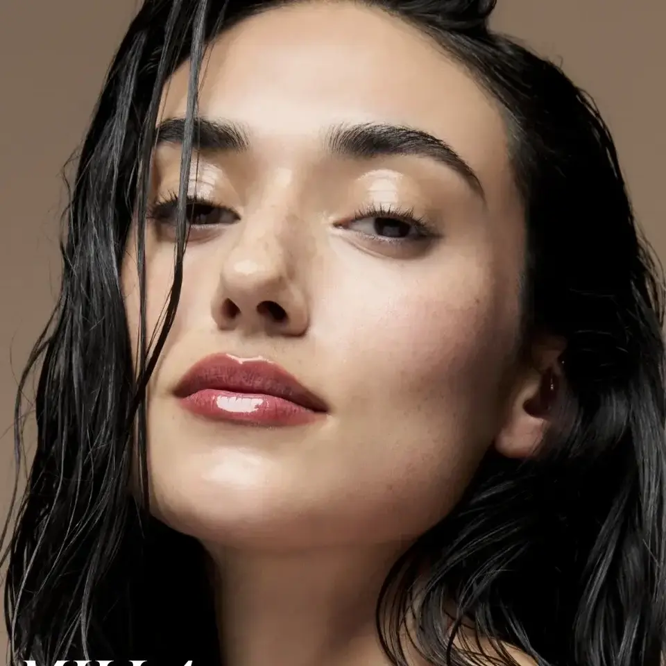 Woman with wet hair and glossy lips on a beige background. Text: "MILLA" in white.