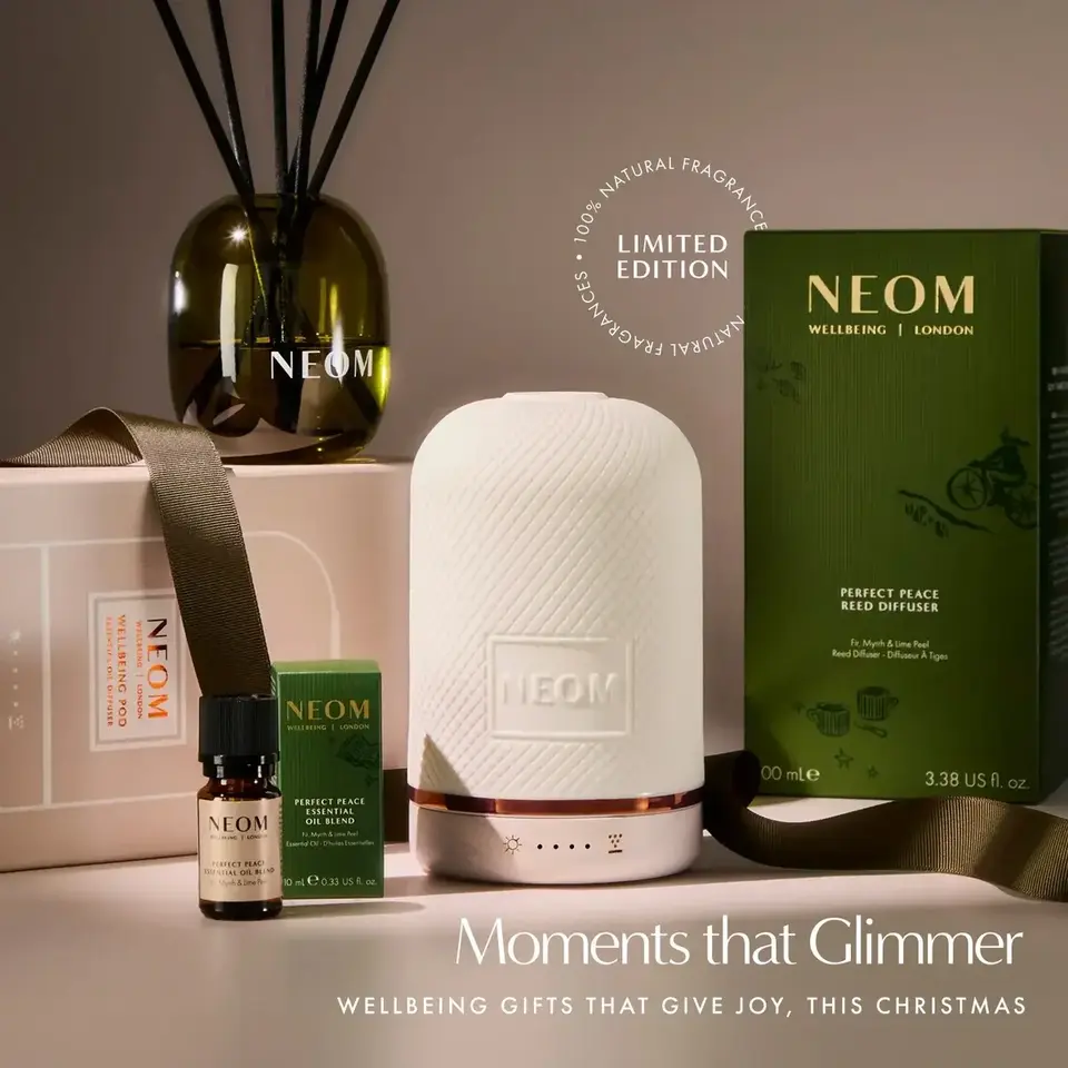 NEOM diffuser set with reed diffuser, oil blend, and packaging. Text: "Moments that Glimmer".