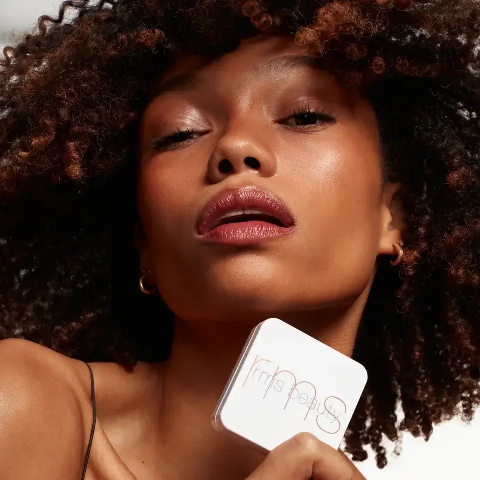 Person holding rms beauty compact, text "BIKINI BEACH" in corner.