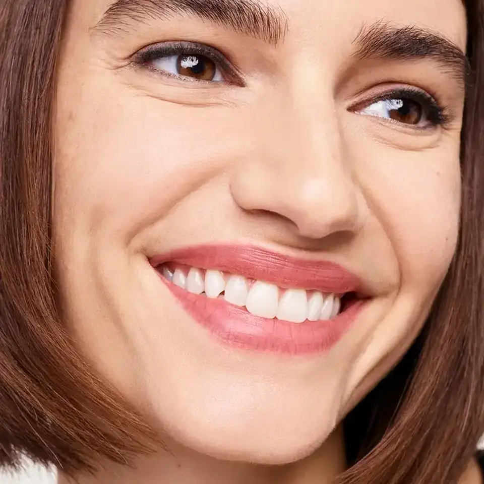 Smiling person with short brown hair and visible teeth.