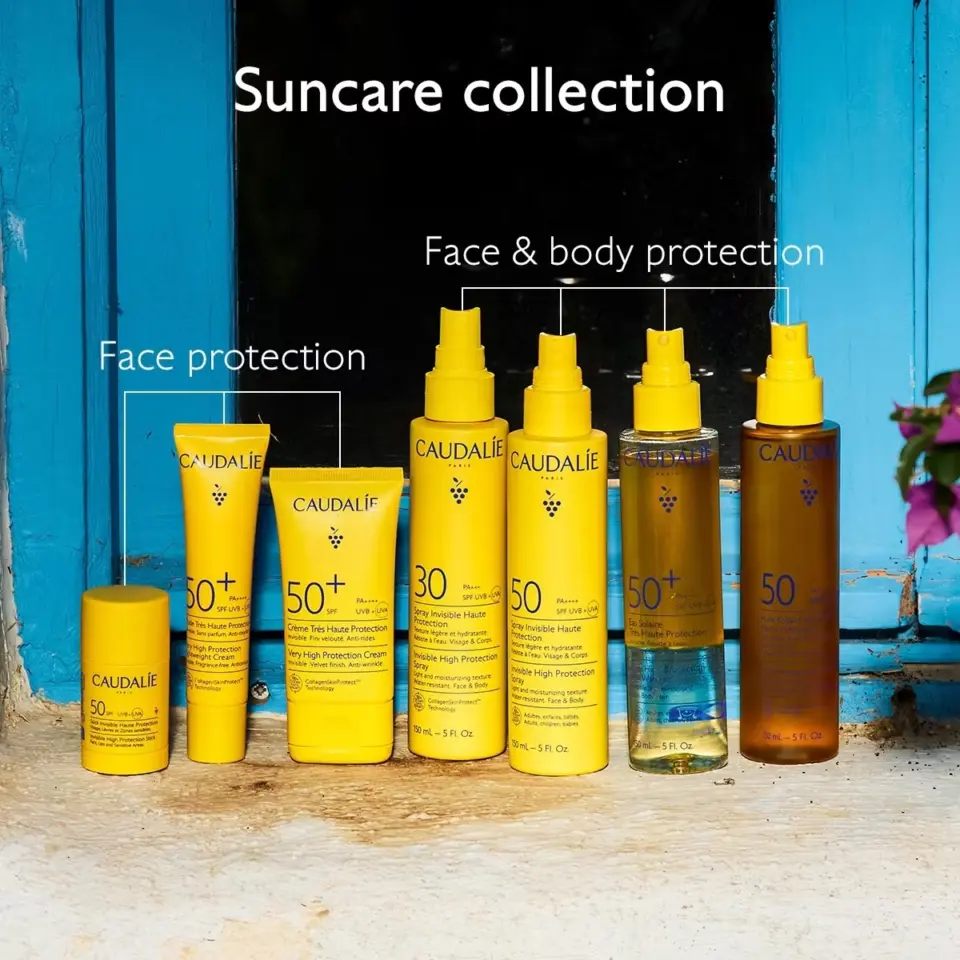 Suncare collection with SPF 30 and 50+ products for face and body by Caudalie on a windowsill.