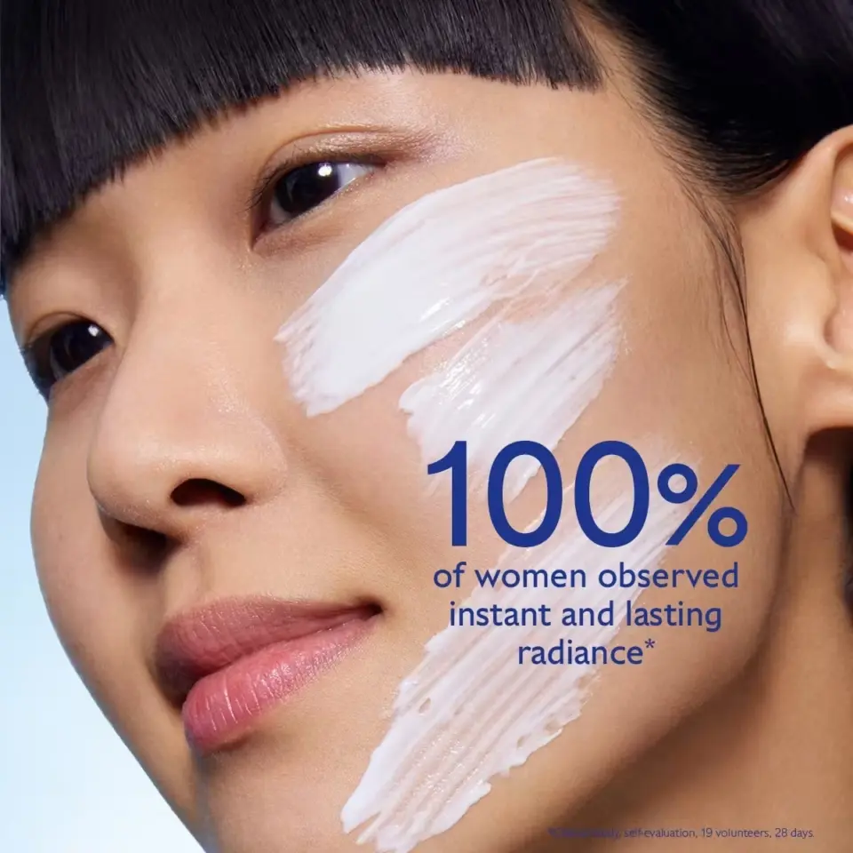Woman with cream on cheek, text: "100% of women observed instant and lasting radiance".