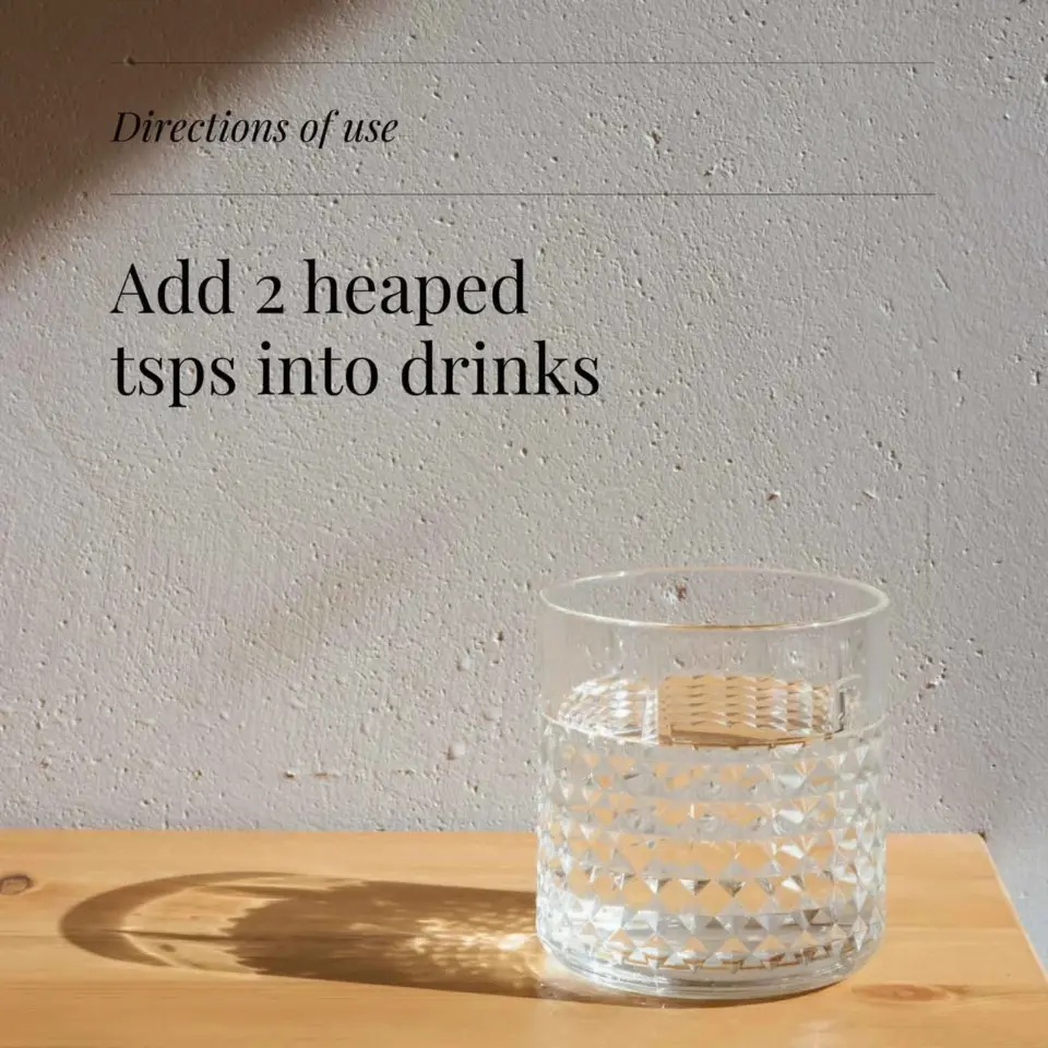 Glass of water on wooden table, text reads: "Add 2 heaped tsps into drinks".