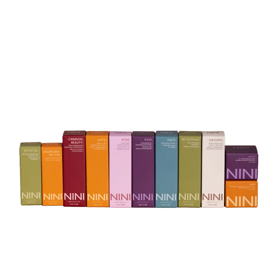 Colourful NINI Organics skincare boxes in a row, each with different product names.