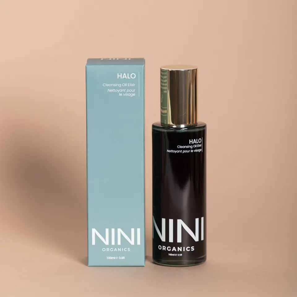 NINI Organics Halo Cleansing Oil Elixir bottle and box on beige background.