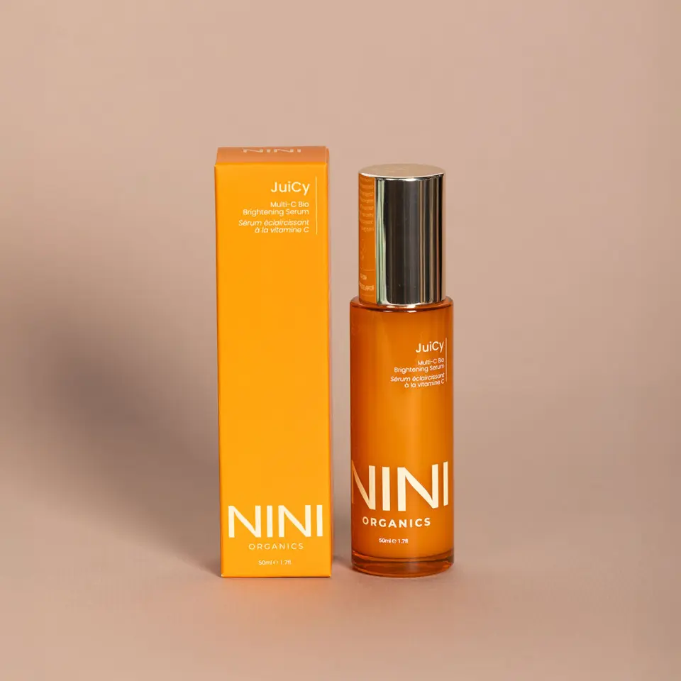 Orange bottle and box of NINI Organics Juicy Multi-C Bio Brightening Serum, 50ml.