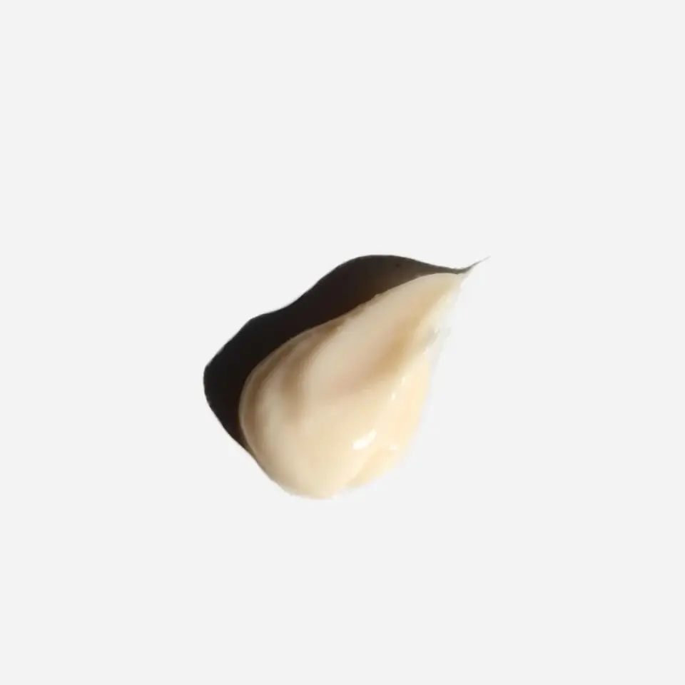 Cream-coloured skincare product dollop on white background.