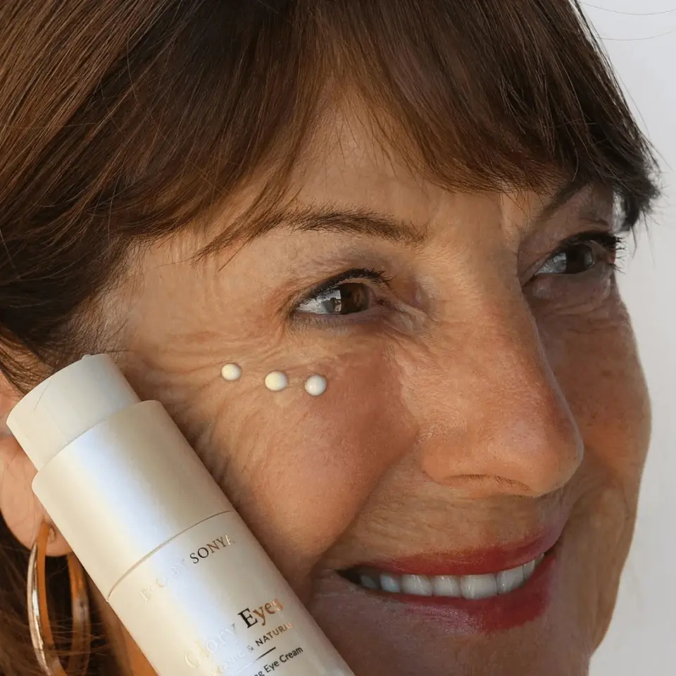 Woman applying eye cream with bottle labelled "Glory Eyes".
