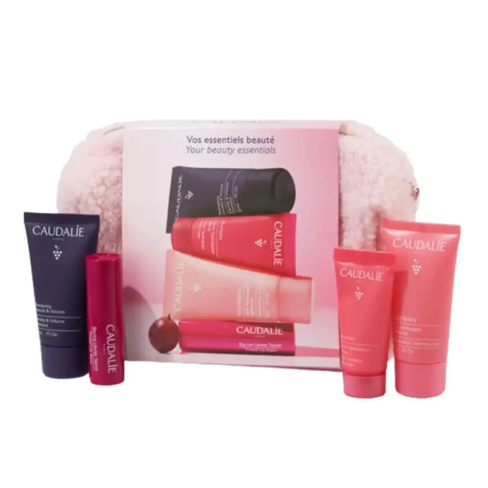 Caudalie beauty essentials set with pink and purple skincare products and a fluffy pouch.