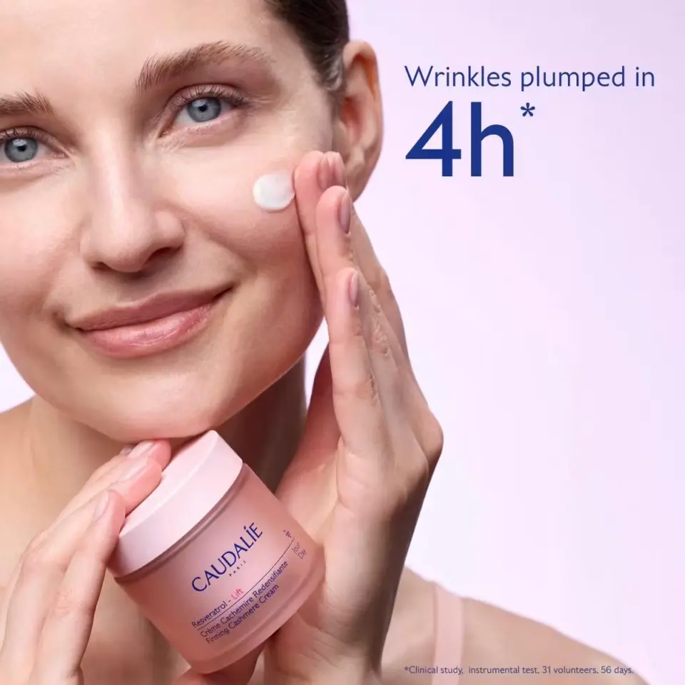 Woman applying Caudalie cream to cheek, text: "Wrinkles plumped in 4h".