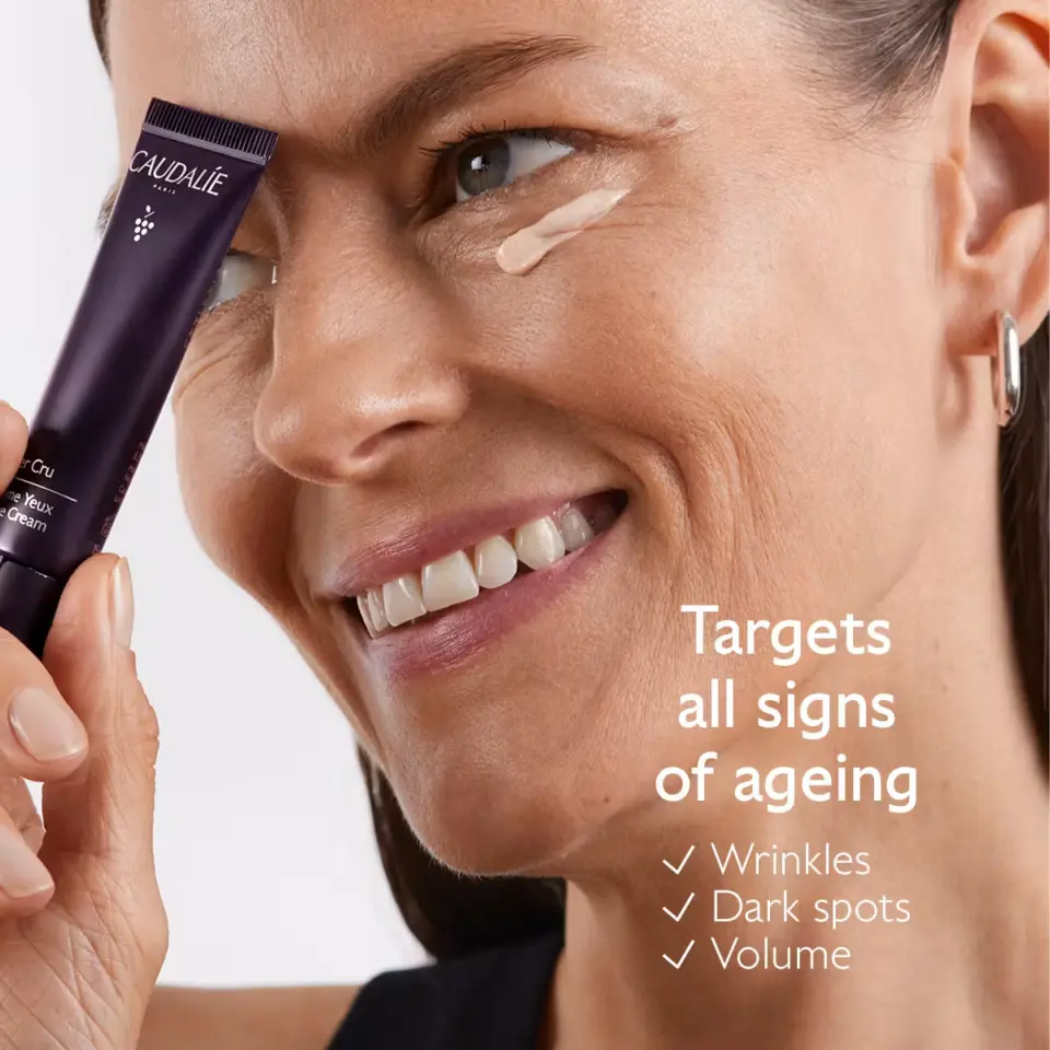 Woman applying eye cream, text: "Targets all signs of ageing: wrinkles, dark spots, volume.