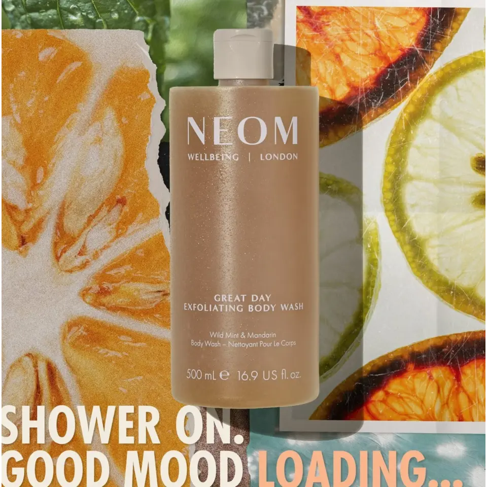 NEOM Great Day Exfoliating Body Wash with citrus slices and text: "Shower on. Good mood loading...