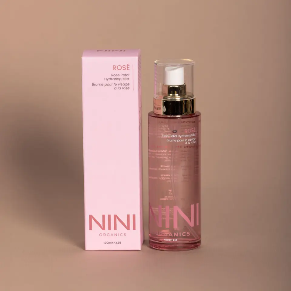NINI Organics Rose Petal Hydrating Mist, 100ml bottle and pink box on beige background.