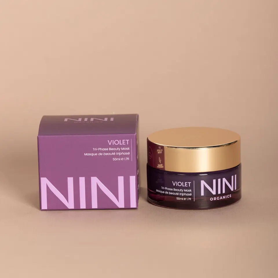 NINI Organics Violet Tri-Phase Beauty Mask, 50ml jar and box on beige background.
