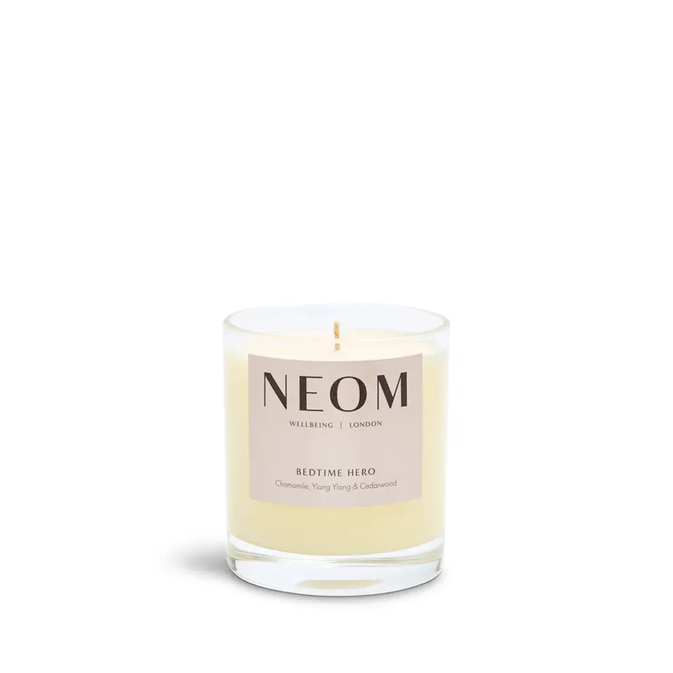 NEOM Bedtime Hero candle with chamomile, ylang ylang, and cedarwood in a glass jar.