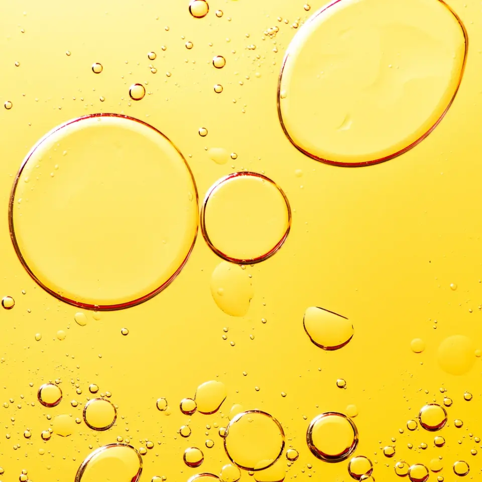Large and small oil bubbles on a yellow background.