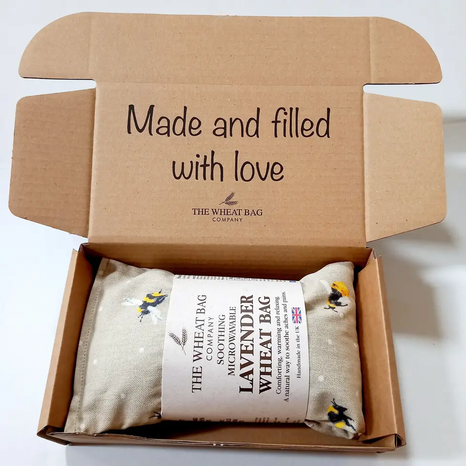 Open box with a lavender wheat bag inside. Text: "Made and filled with love".