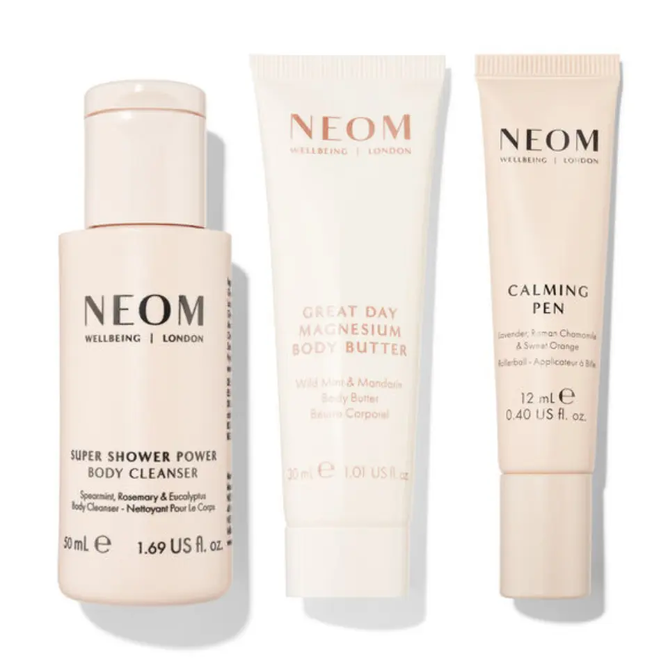 Three NEOM products: body cleanser, magnesium body butter, and calming pen.