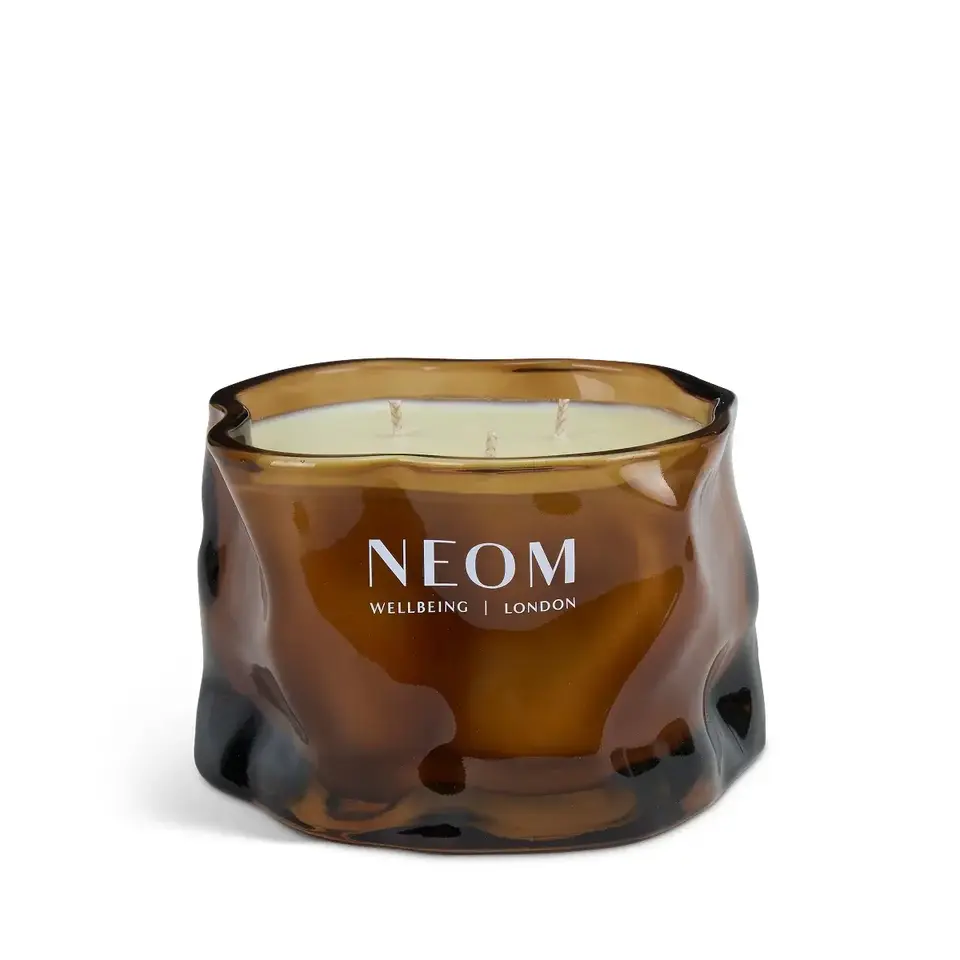 Brown glass candle with three wicks, labelled "NEOM Wellbeing London".