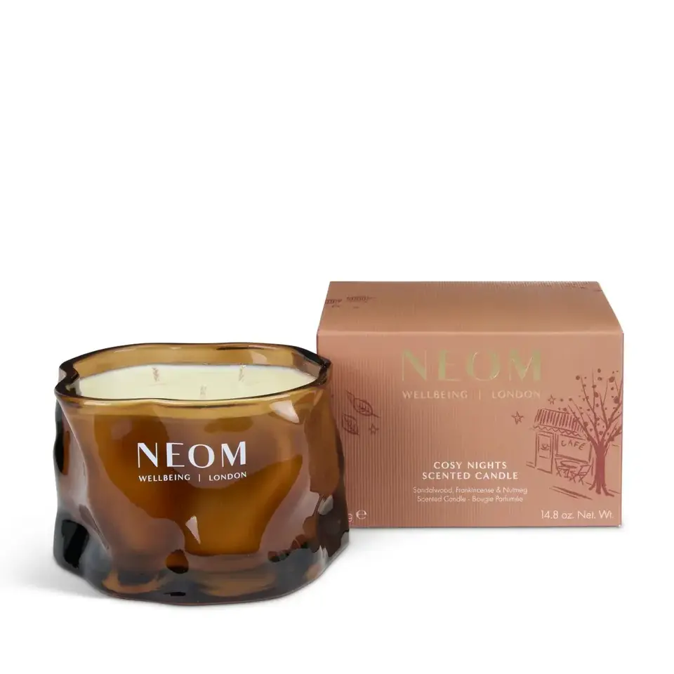 Brown glass candle jar with "NEOM Wellbeing London" text, next to a matching box.