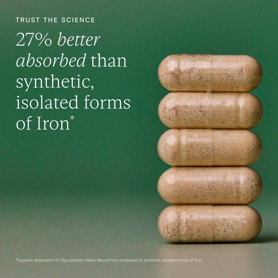 Five beige capsules stacked on a green background with text about iron absorption.