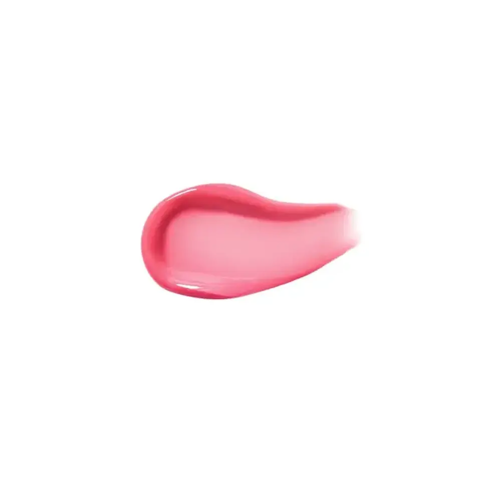 Pink skincare cream smear on white background.