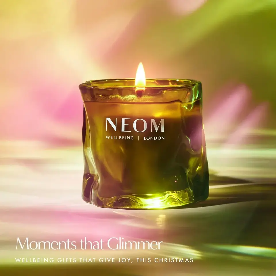 Green candle with flame, labelled "NEOM Wellbeing London". Text: "Moments that Glimmer".