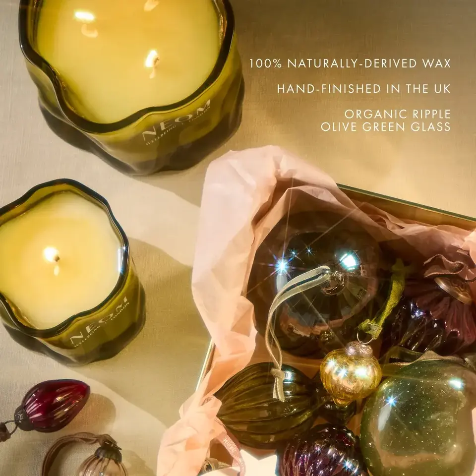 Candles in olive green glass with baubles and text about natural wax and UK hand-finishing.