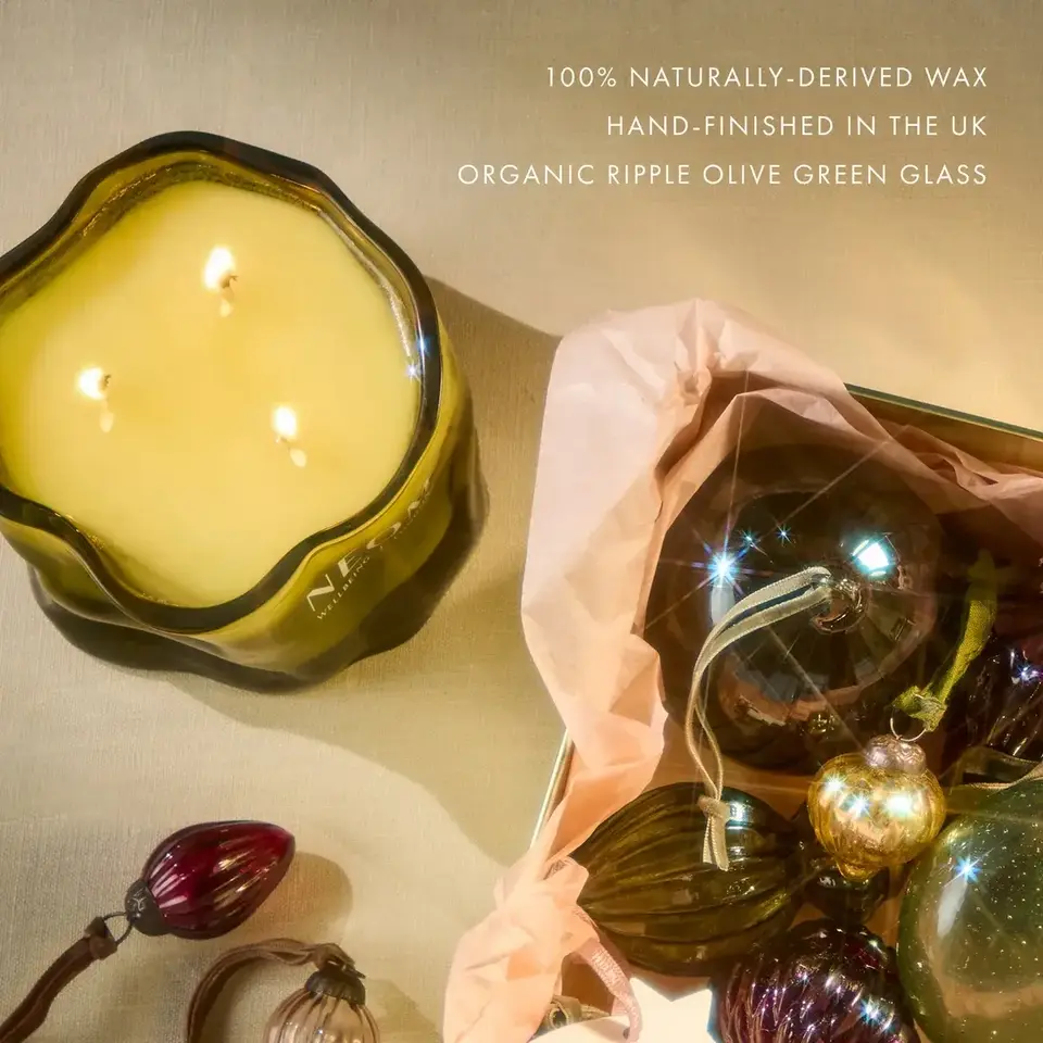 Olive green candle with three wicks, glass baubles, and text about natural wax and UK hand-finishing.