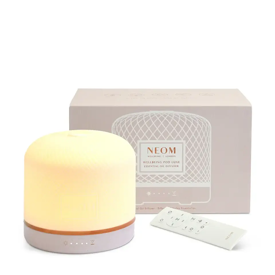 Essential oil diffuser with remote and packaging. Neom branding visible.