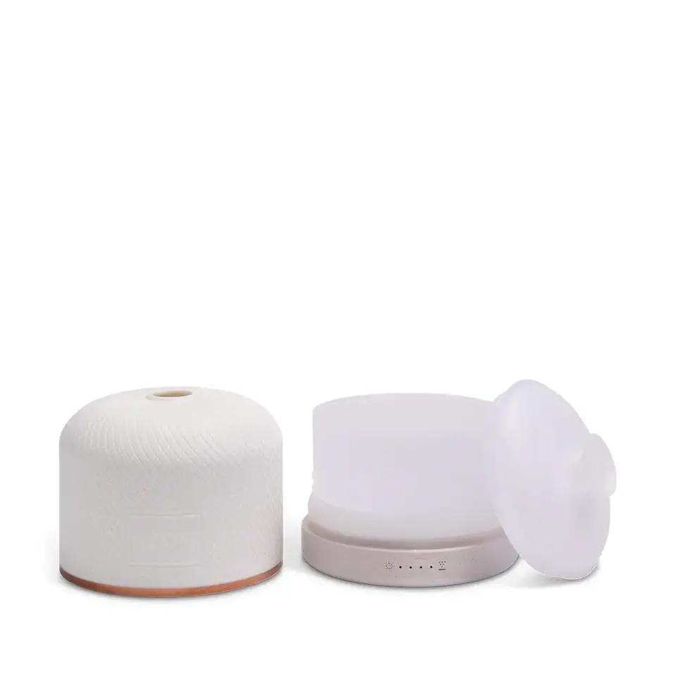 White essential oil diffuser with removable lid and control buttons.