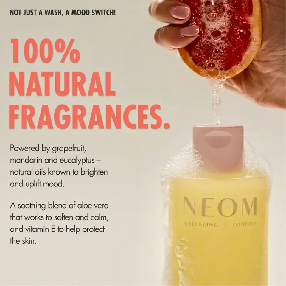 100% natural fragrances text, grapefruit held over NEOM Wellbeing London bottle with bubbles.