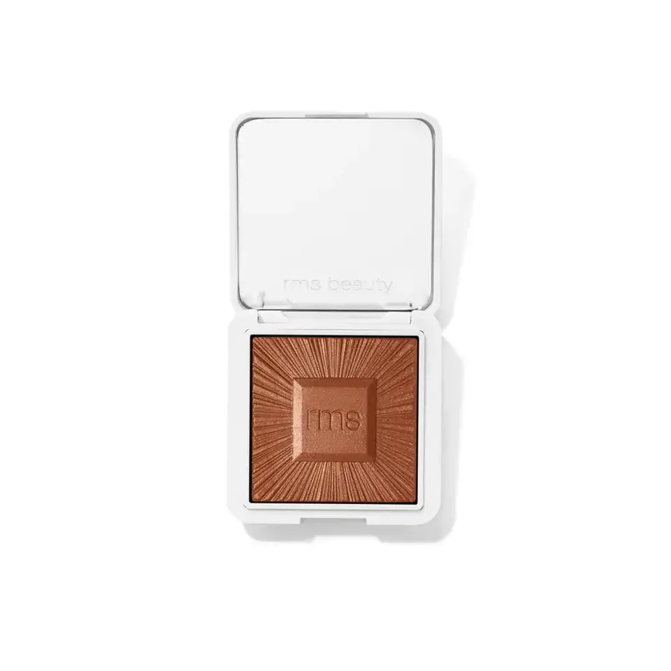 Open compact with bronze powder, "rms beauty" embossed on lid and powder.